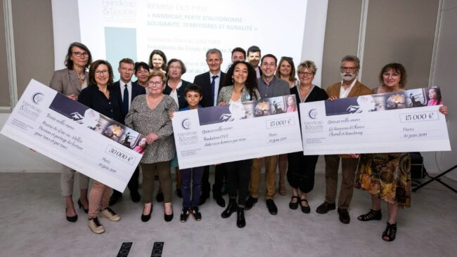 Design sans titre Photo d'un groupe de personnes tenant entre leurs mains de grands chèques à l'ordre du Fonds Handicap & Société