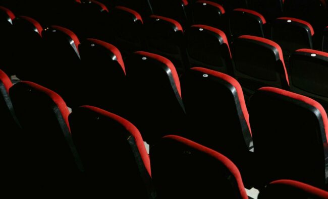 cinema-fauteuils-rouges Salle de cinéma vide avec ses fauteuils rouges