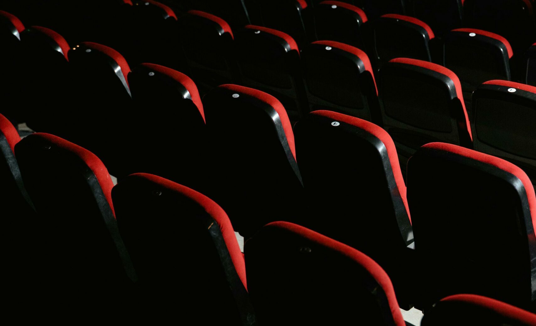 Salle de cinéma vide avec ses fauteuils rouges