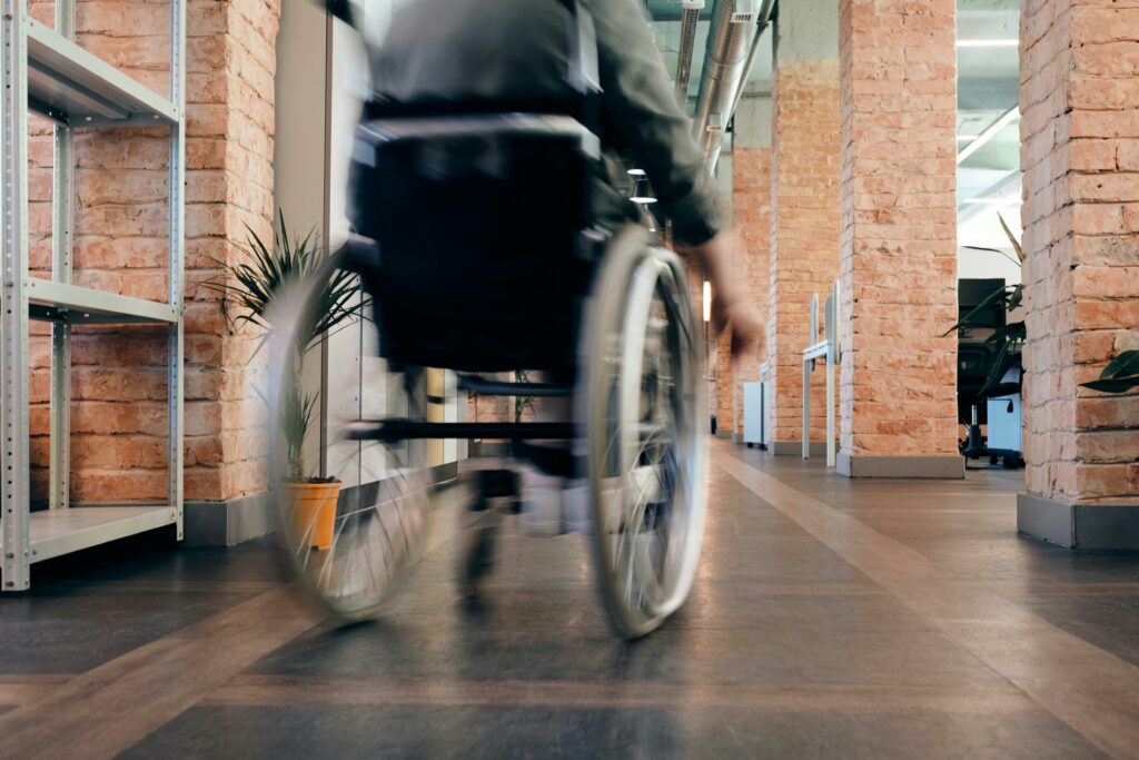 Une personne en chaise roulante passe dans un couloir