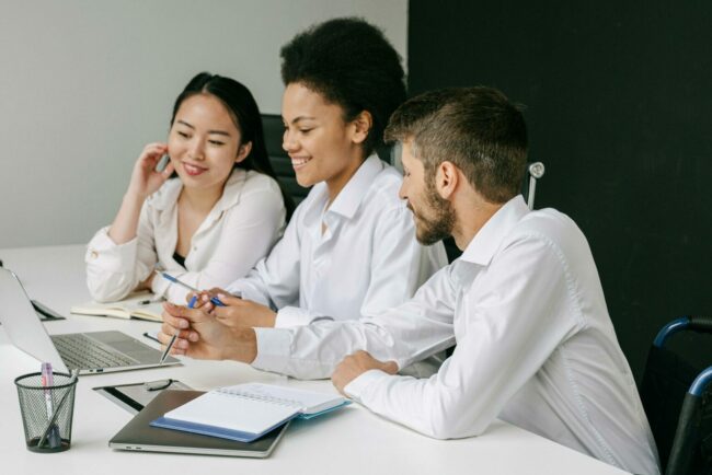 Trois collègues autour d'une table de bureau