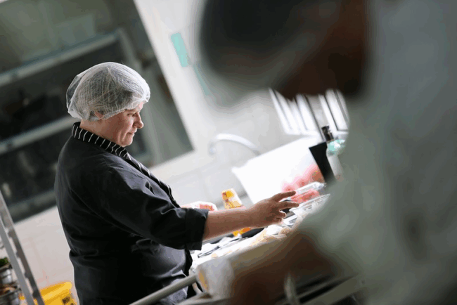 Une femme travaillant dans une cuisine de restauration collective