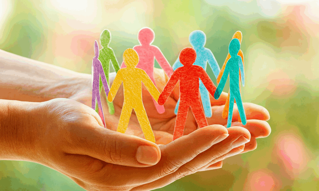 Illustration de mains ouvertes tenant une ribambelle en papier de silhouettes humaines de toutes les couleurs