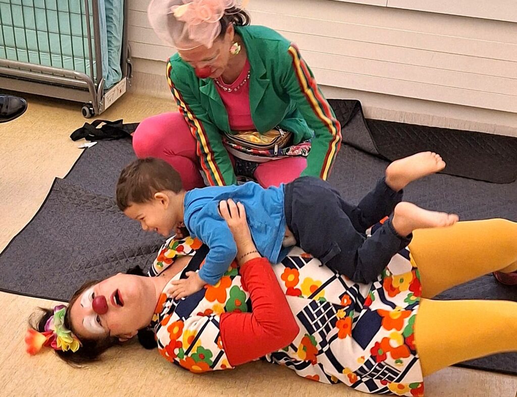 Deux clowns jouent avec un enfant hospitalisé