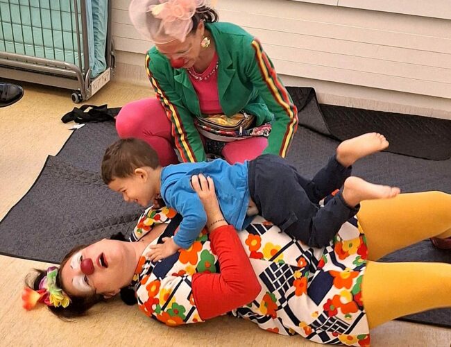 Deux clowns jouent avec un enfant hospitalisé