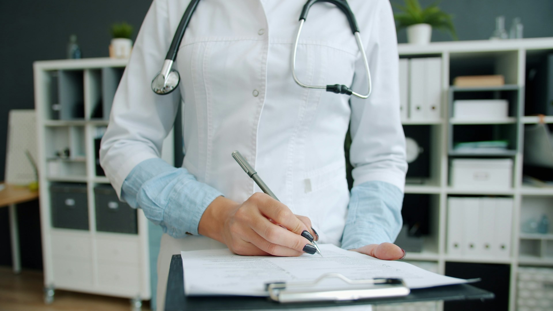 Une médecin remplit un formulaire dans son cabinet médical
